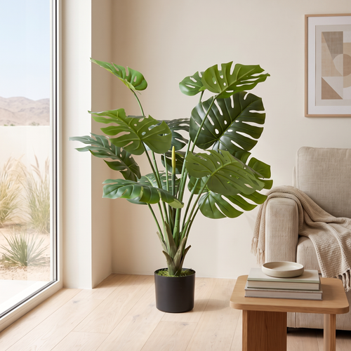 100cm artificial Monstera plant in a black pot in a bright Muscat living room corner by the window