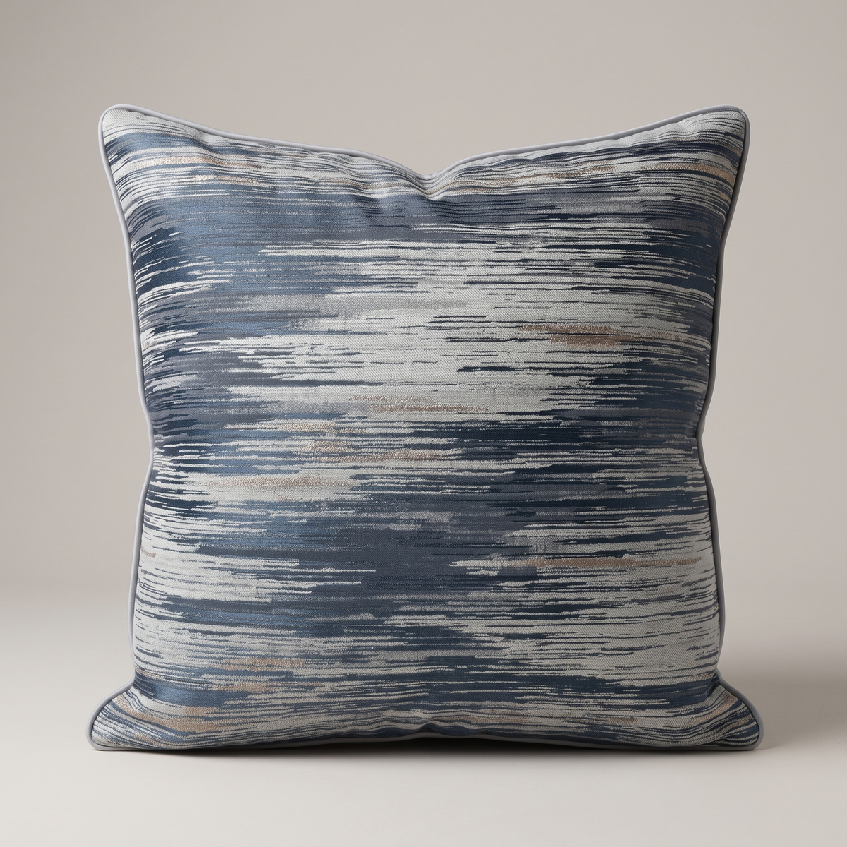 Blue and gold cushion studio shot on a pale warm-grey backdrop