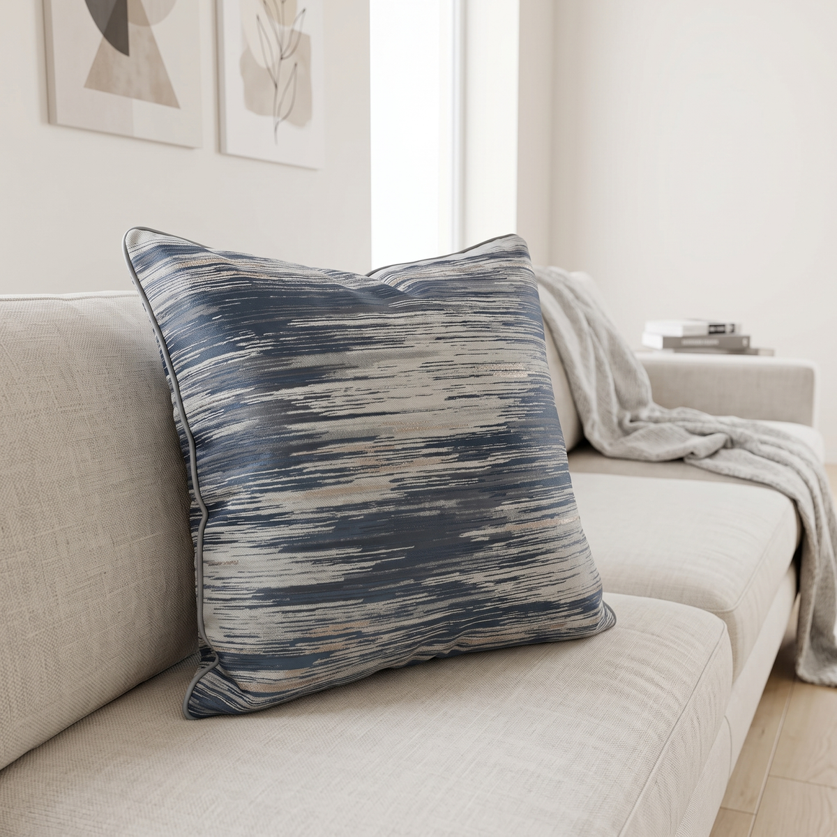 Blue and gold cushion propped in the corner of a linen sofa