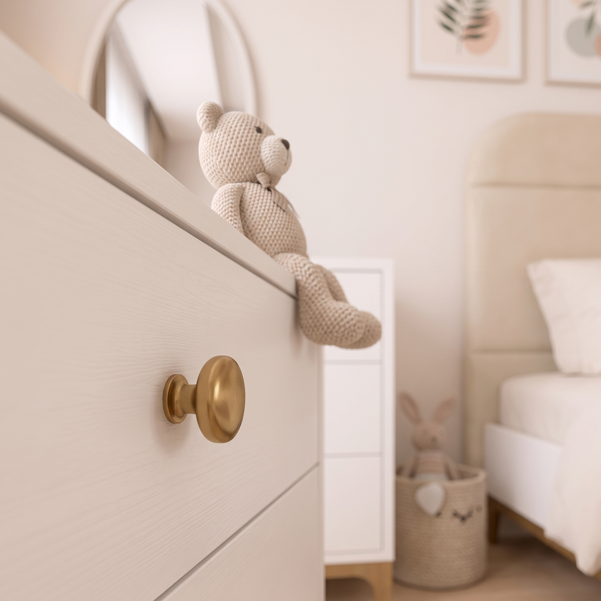 Detail of a brass knob on the white dresser with a knitted soft toy