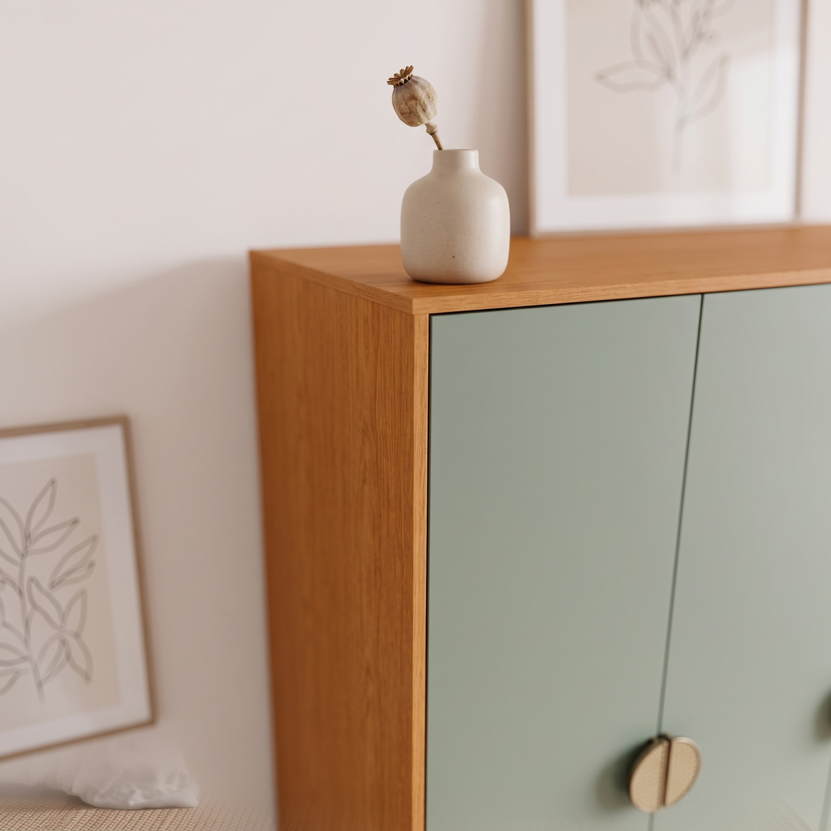 Detail of the cinnamon frame meeting the sage green door with a ceramic vase on top