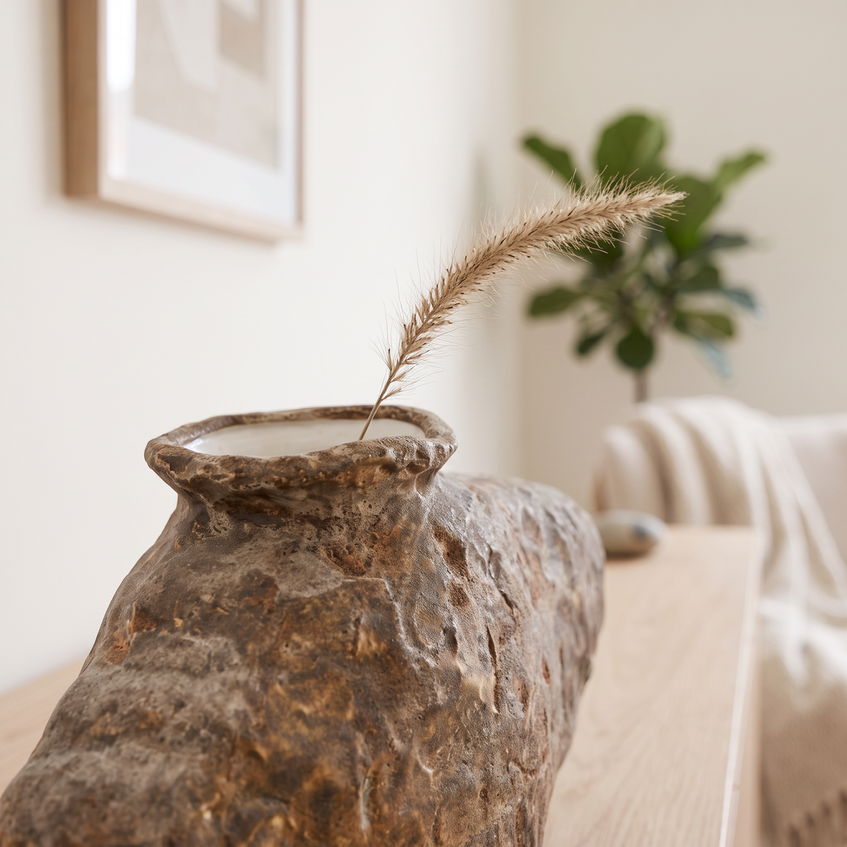Vase opening with a single dried grass stem