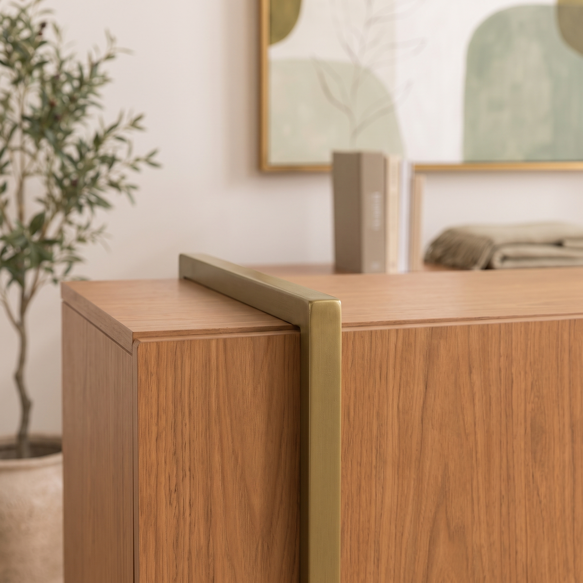 Close-up of the olive-bronze rail and corner detail against the Freijo wood grain