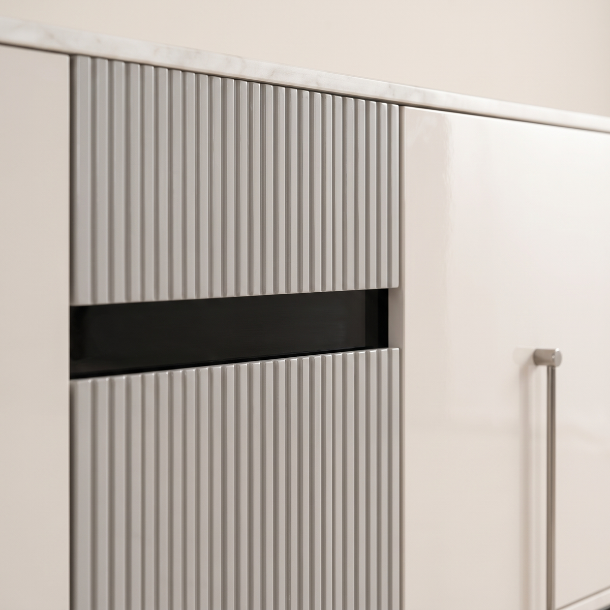 Detail of the grey fluted drawers, dark recessed pull and silver bar handle