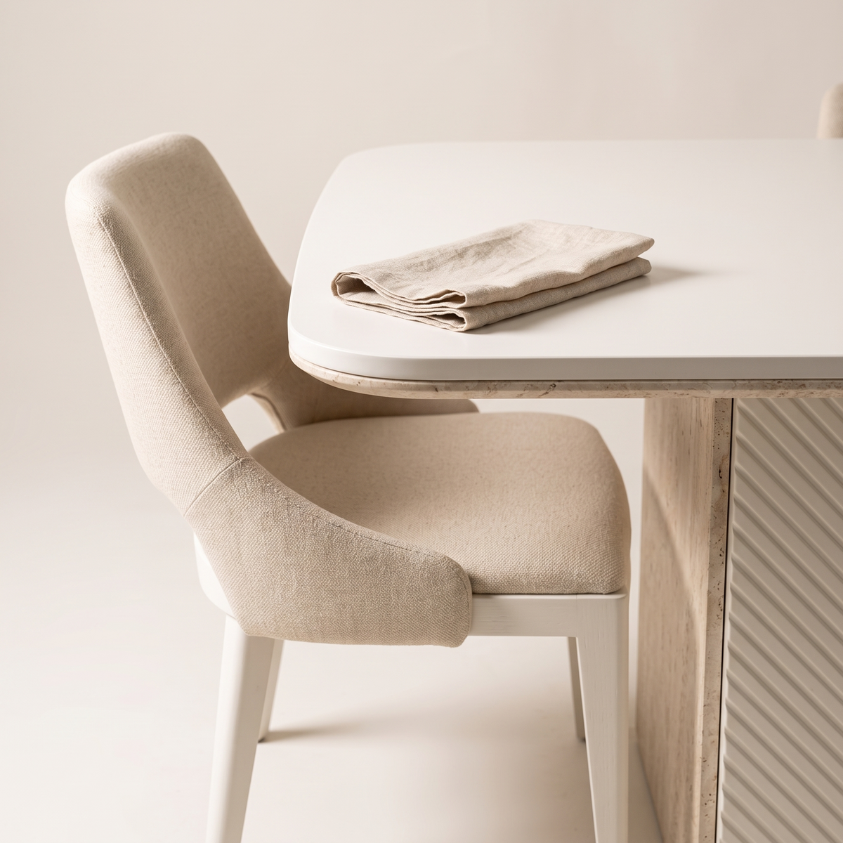 Alfa dining chair beside the matte white table top with a linen napkin