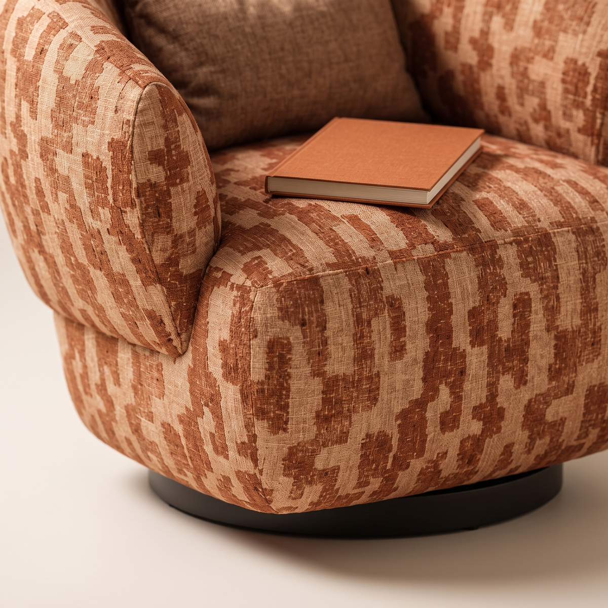 Rota armchair seat front and dark circular plinth base with a book