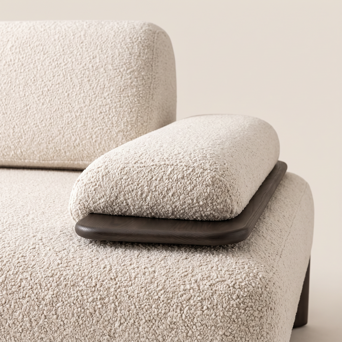 Detail of the boucle arm cushion resting in its dark wood tray