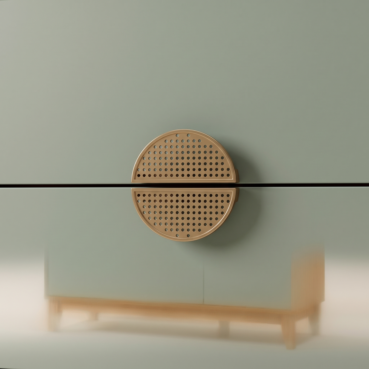 Detail of the round perforated split-disc handle across two sage green drawers